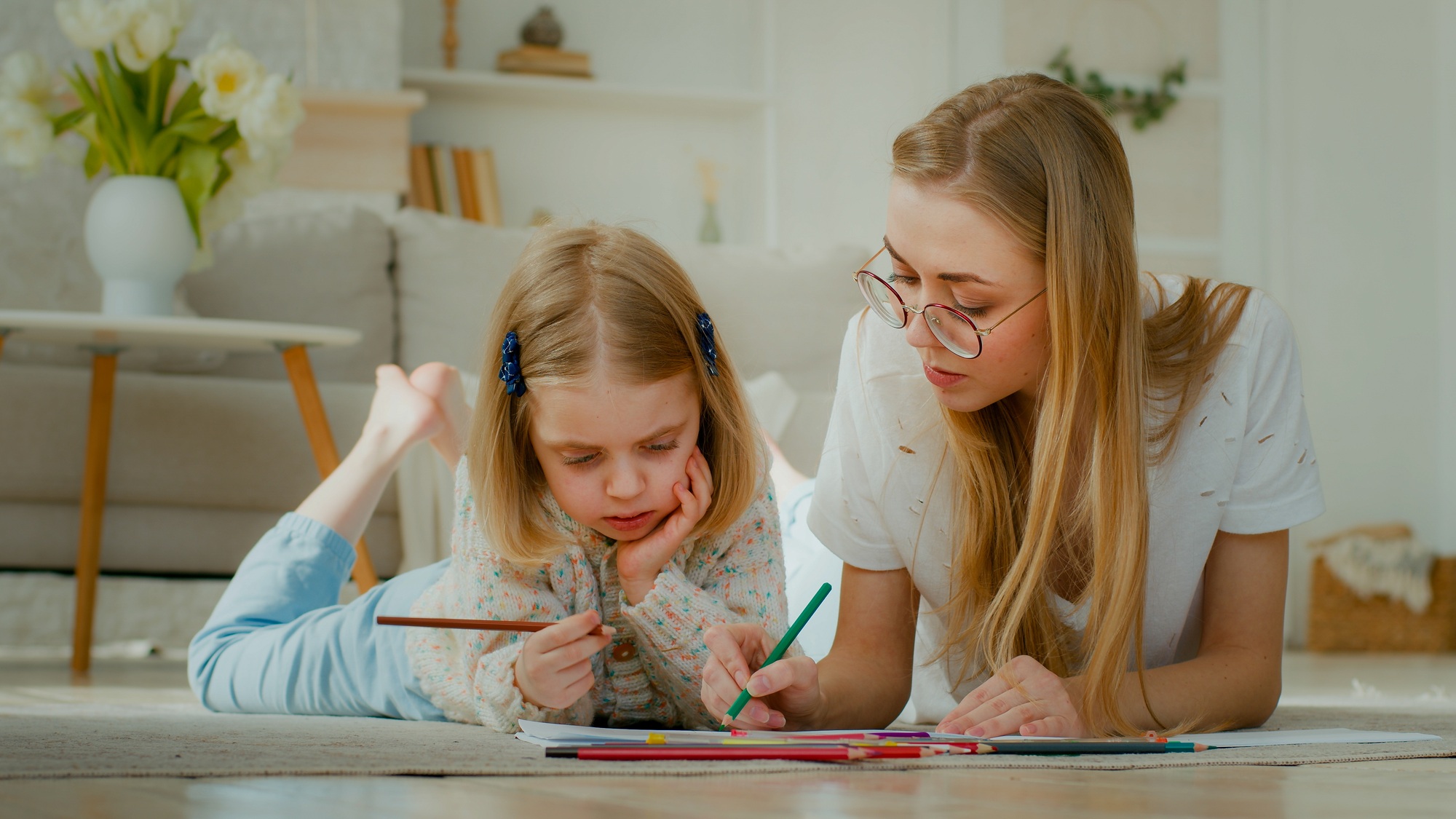 Caucasian mum nanny babysitter helping cute kid daughter teaching toddler child girl drawing picture