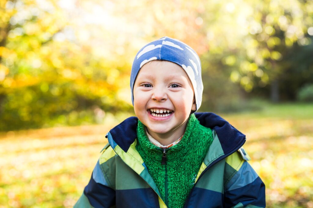 Happy child enjoying a sunny autumn day in the park