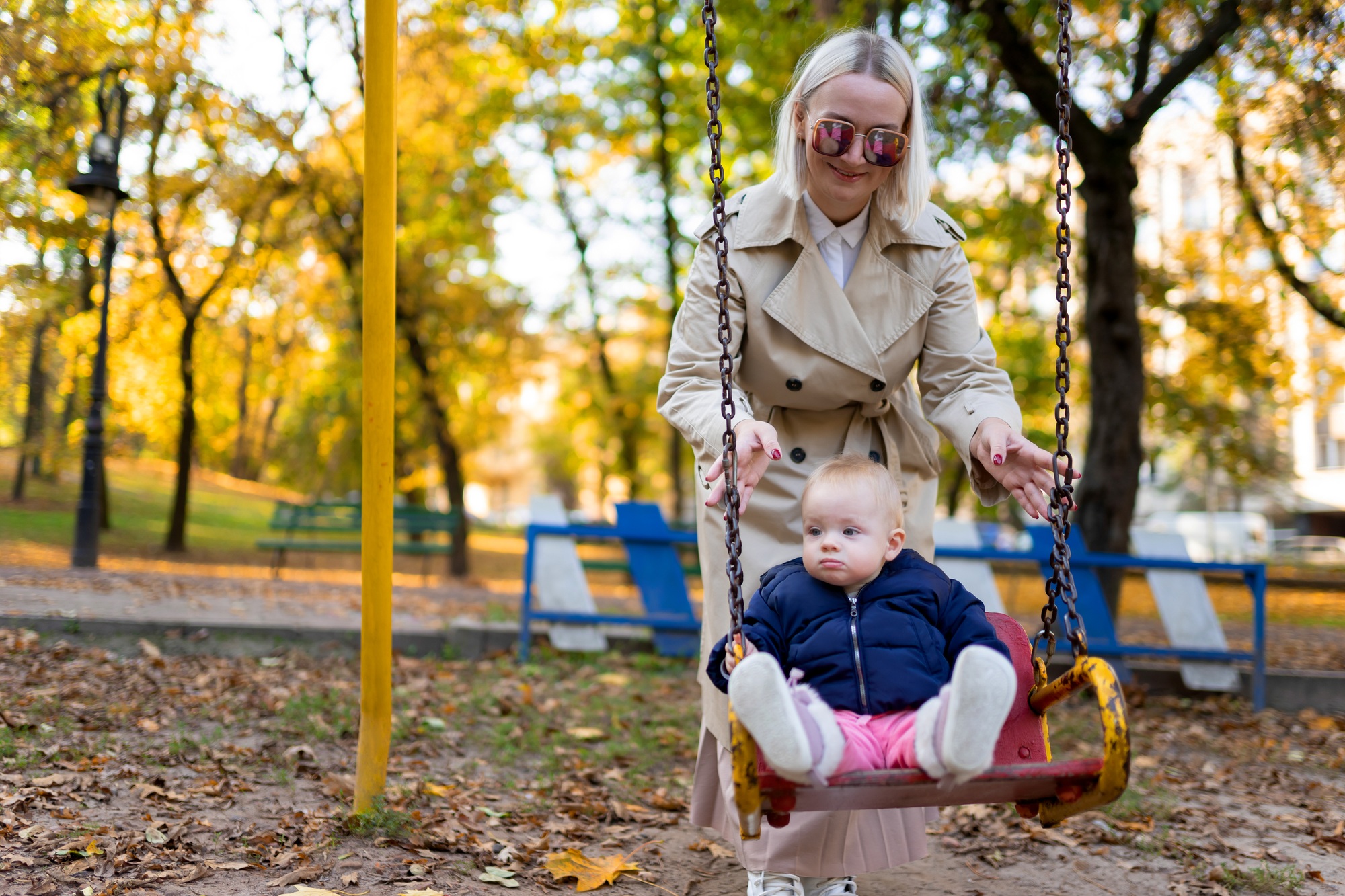 Mother playing with baby on swing